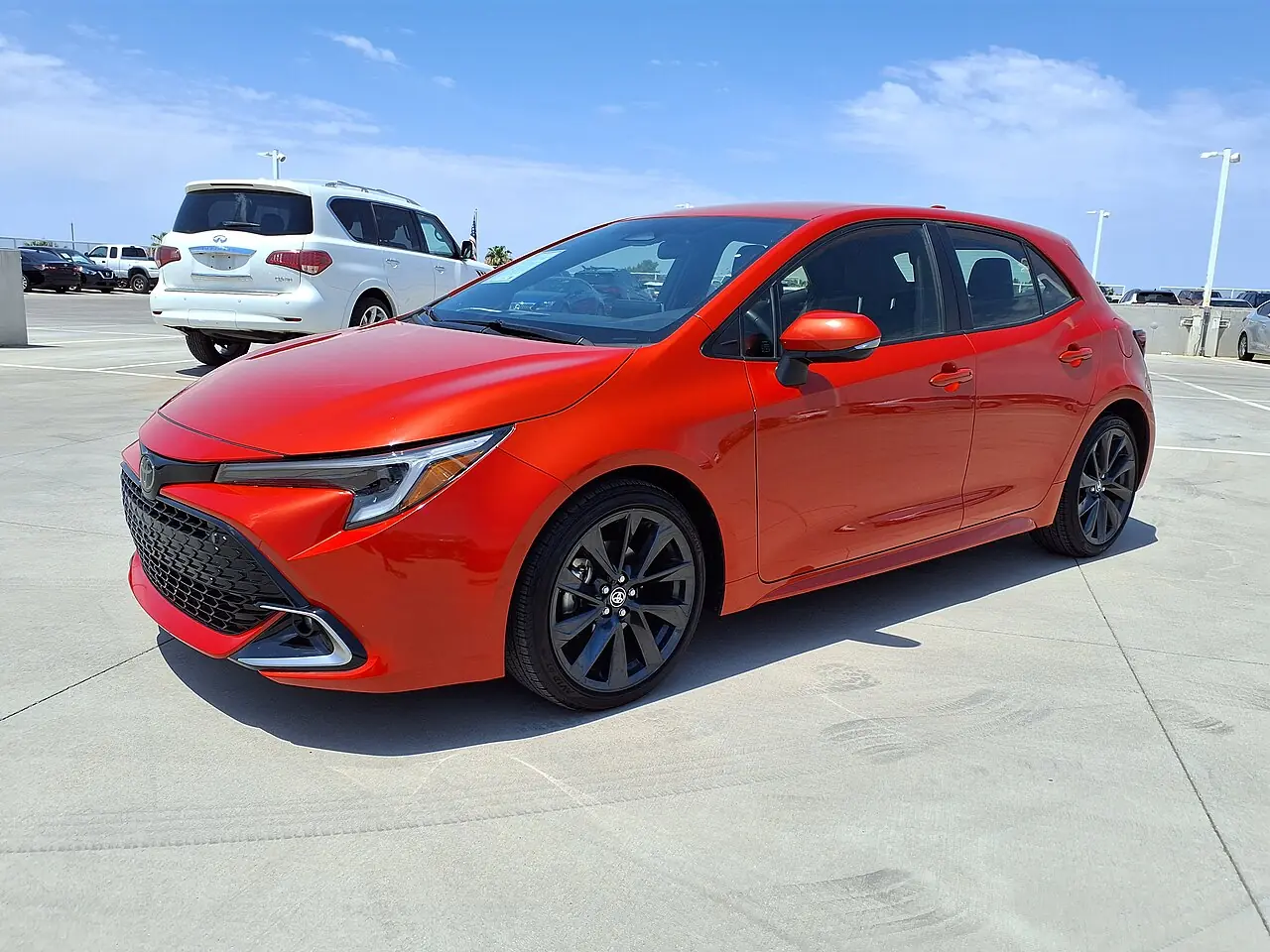 Красный хэтчбек Toyota Corolla, вид спереди и сбоку