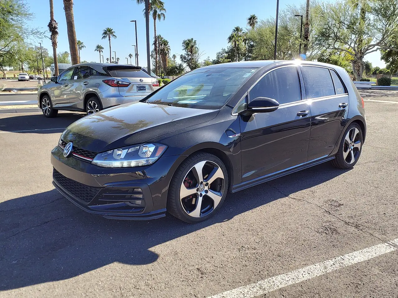 Volkswagen Golf VII GTI тёмного цвета, вид спереди и сбоку